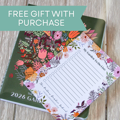 Floral-themed garden planner with a free gift notepad on a wooden surface